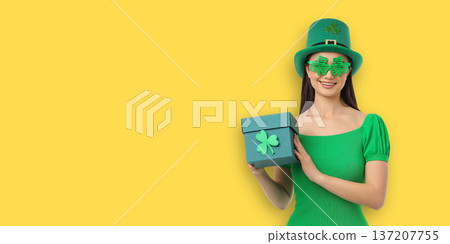 Young woman in festive wear holding a green gift box Young woman in festive wear holding a green gift box 137207755