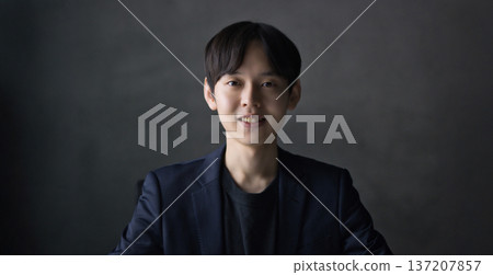 一名二十多歲的男子對著鏡頭微笑 137207857