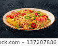 Hakka noodles with vegetables, peppers and green onions, on black 137207886