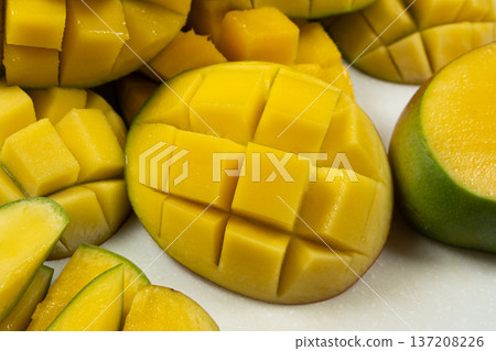 Juicy mango halves with cube cut pattern. Juicy mango halves with cube cut pattern. 137208226
