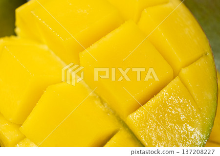 Juicy mango halves with cube cut pattern. Juicy mango halves with cube cut pattern. 137208227
