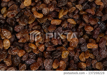 Macro top view of dried grapes, sweet organic raisins. Macro top view of dried grapes, sweet organic raisins. 137208228