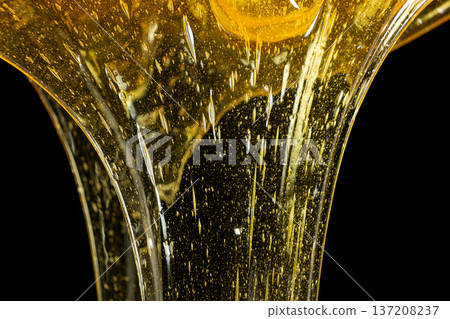 Luxury golden honey dripping on black background. 137208237