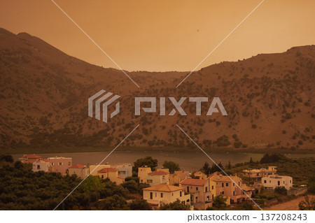 Apocalyptic landscape: lake Kournas, Crete 2025, covered in orange african dust storm and poor visibility 137208243