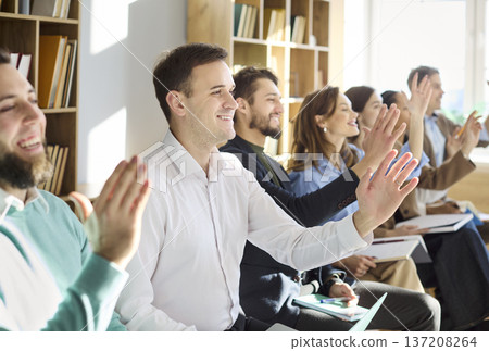 Smiling office audience raising hands to ask questions at training workshop Smiling office audience raising hands to ask questions at training workshop 137208264