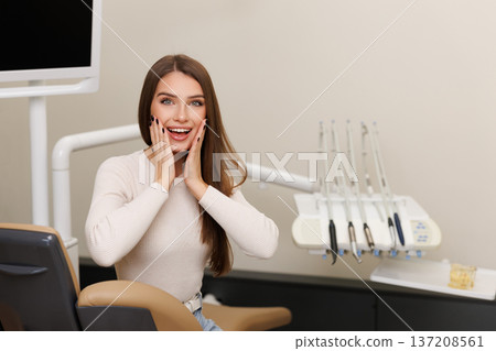 Woman is happy with results for oral hygiene and teeth whitening at dentist. Patient is smiling at the camera after tooth cleaning Woman is happy with results for oral hygiene and teeth whitening at dentist. Patient is smiling at the camera after tooth cleaning 137208561