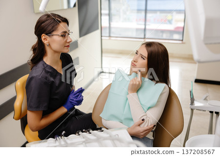 Young woman experiencing pain and anxiety while having a dental procedure performed on her Young woman experiencing pain and anxiety while having a dental procedure performed on her 137208567