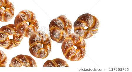 Multiple twisted pretzel buns or bagel with coarse salt topping arranged in seamless pattern isolated on white background 137208735
