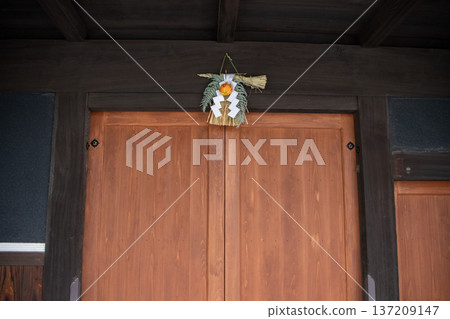 Shimenawa rope attached to the gate of an old house with traditional Japanese architecture Shimenawa rope attached to the gate of an old house with traditional Japanese architecture 137209147