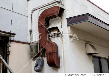 Old and rusty ventilation duct (exhaust duct) installed on the exterior wall of a building Old and rusty ventilation duct (exhaust duct) installed on the exterior wall of a building 137209446