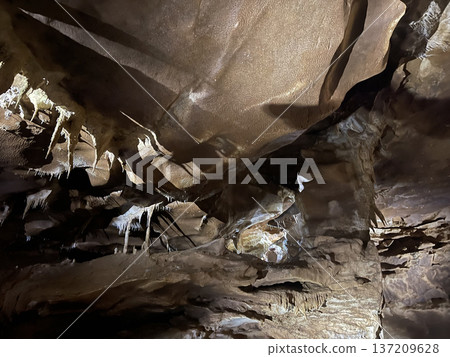 Mysterious cave with stalactites. Grunge karst texture background Mysterious cave with stalactites. Grunge karst texture background 137209628