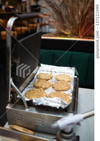 Burger patties cooking on open contact grill Burger patties cooking on open contact grill 137211499