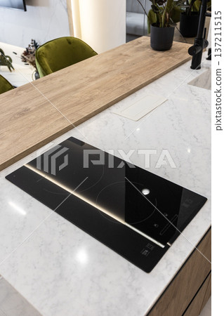 Induction cooktop on marble kitchen island countertop Induction cooktop on marble kitchen island countertop 137211515