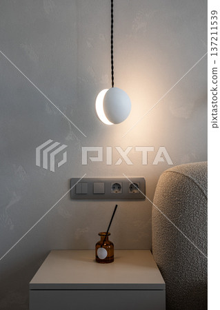 Minimal bedside wall lamp above nightstand Minimal bedside wall lamp above nightstand 137211539