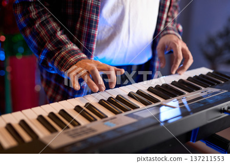 A close-up of hands playing a digital keyboard synthesizer A close-up of hands playing a digital keyboard synthesizer 137211553