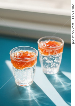 Two glasses containing liquid drinks 137212064
