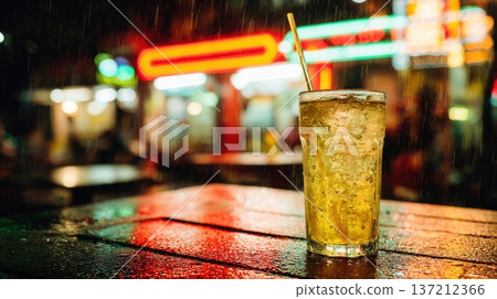 Close-Up of Sparkling Drink in Glass on Table with Rain Background and Neon Lights 137212366