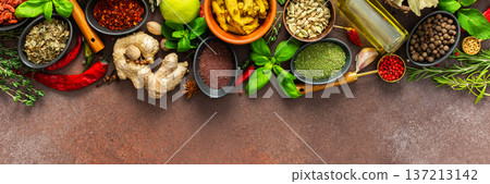 A rich palette of colorful spices and herbs, resting on a brown background, radiating freshness and an inviting aroma, perfect for gourmet inspiration, banner 137213142
