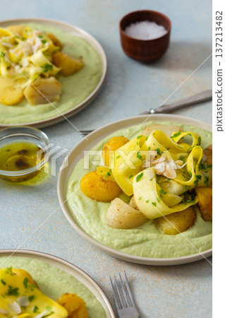 Baked potatoes are topped with slices of fermented zucchini and served alongside a green pea sauce with broccoli. This meal is prepared for a healthy breakfast Baked potatoes are topped with slices of fermented zucchini and served alongside a green pea sauce with broccoli. This meal is prepared for a healthy breakfast 137213482
