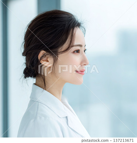 一位身穿白大褂的年輕女子側過臉去 一位身穿白大褂的年輕女子側過臉去 137213671