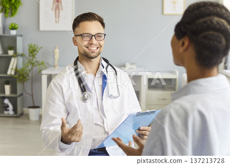 Happy Doctor Consulting Patients In Hospital 137213728