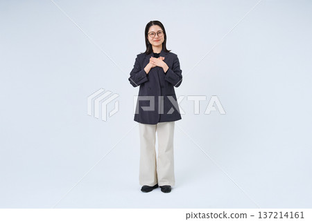 A businesswoman posing with her hand on her chest 137214161