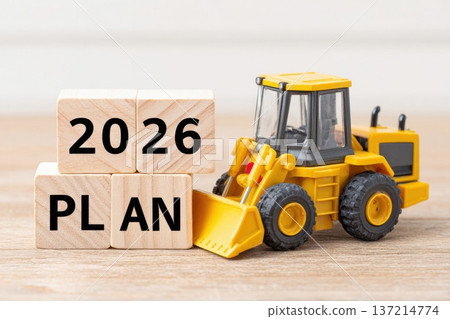 Toy bulldozer with wooden blocks displaying 2026 plan text, set on a wooden surface, symbolizing construction, planning, and future projects in a playful environment 137214774