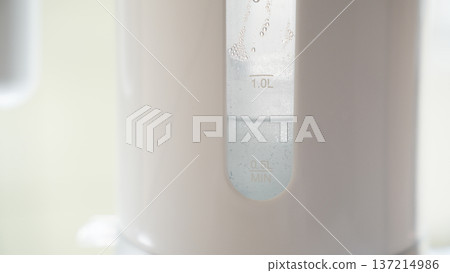 Close up of electric kettle water level window showing measurement marks and condensation droplets Close up of electric kettle water level window showing measurement marks and condensation droplets 137214986