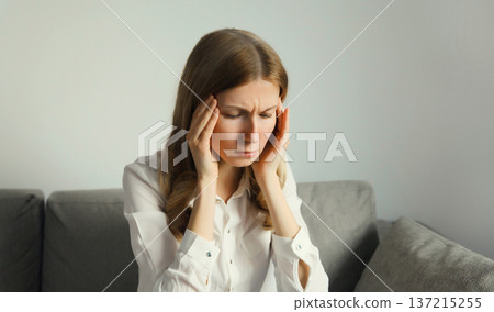 Exhausted tired woman suffering from headache, stress, fatigue, temples pain, migraine, loud noise Exhausted tired woman suffering from headache, stress, fatigue, temples pain, migraine, loud noise 137215255