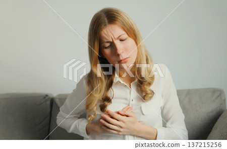 Unhealthy woman touching hands chest suffering from heart pain, feeling bad, heart health problems Unhealthy woman touching hands chest suffering from heart pain, feeling bad, heart health problems 137215256