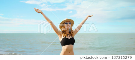 Summer vacation, beautiful happy woman in bikini swimsuit raising her hands up on the beach at sea Summer vacation, beautiful happy woman in bikini swimsuit raising her hands up on the beach at sea 137215279