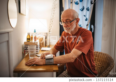 Senior man measuring blood pressure with wrist monitor. 137215514
