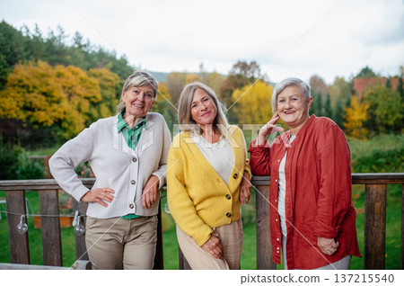 Portrait of three smiling senior women together outdoors. Portrait of three smiling senior women together outdoors. 137215540