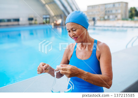 Senior woman getting ready for swim. Senior woman getting ready for swim. 137215585