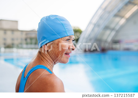 Older female swimmer getting ready for regular fitness swimming. 137215587