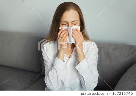 Sick exhausted young woman sneezing blow nose using tissue, unhealthy suffering girl feels unwell Sick exhausted young woman sneezing blow nose using tissue, unhealthy suffering girl feels unwell 137215740