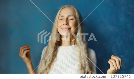 Calm relaxed healthy mature woman meditates, practicing doing yoga exercises, with closed eyes Calm relaxed healthy mature woman meditates, practicing doing yoga exercises, with closed eyes 137215745