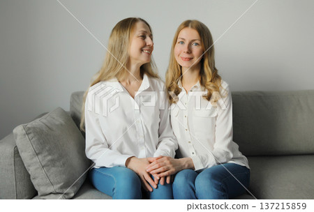 Family portrait, happy two women, smiling mature mother and adult daughter together hugging at home 137215859