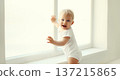 Little baby looking out the window in white room at home 137215865