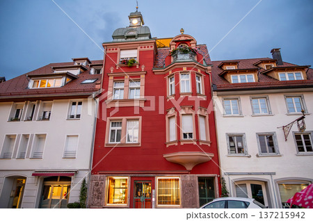 Wangen, germany, august 17, 2023. Historic red building featuring an ornate facade, bay windows, and a small turret against a blue sky at dusk in wangen im allgau 137215942