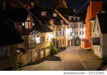 Wangen, germany, august 17, 2023. Wangen im allgau old town street winding between traditional houses with illuminated windows and a cobblestone road at night 137215943