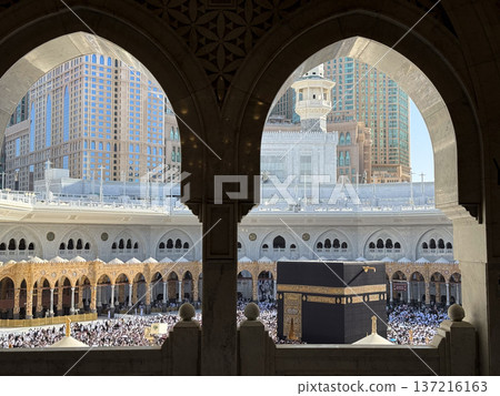 Pilgrims circling the Kaaba at Masjid al-Haram in Mecca with crowds framed by mosque arches Pilgrims circling the Kaaba at Masjid al-Haram in Mecca with crowds framed by mosque arches 137216163