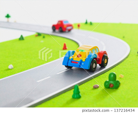 A three-dimensional CG representation of a toy car driving on a miniature road, in a pixelated style. A three-dimensional CG representation of a toy car driving on a miniature road, in a pixelated style. 137216434