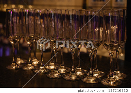 Champagne Glasses Awaiting Celebration. Sophisticated Setting Featuring Empty Flutes Champagne Glasses Awaiting Celebration. Sophisticated Setting Featuring Empty Flutes 137216510