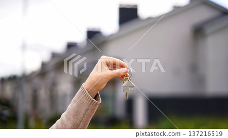 Woman Buyer Holds House Key, Real Estate Owner Offers Property. New Resident Moves Into Row Townhouse, Owner Rents Out Housing. Investment, Buying Apartment, Relocation, Housing Service. 137216519
