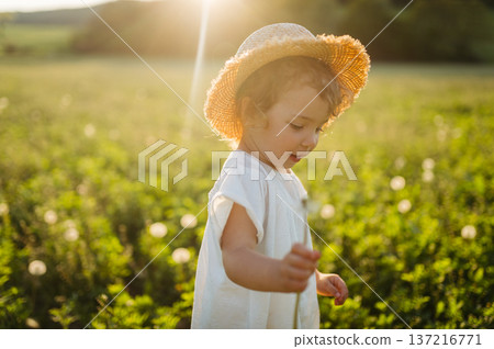Cute girl playing on meadow, in spring nature. Cute girl playing on meadow, in spring nature. 137216771