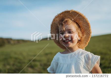 Cute girl playing on meadow, in spring nature. 137216772