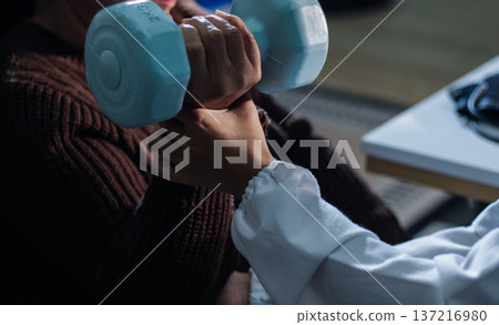 doctor is checking for muscle injuries and using dumbbells test injury and also help with physical therapy strengthen muscles because physical therapy will help strengthen muscles and help blood flow doctor is checking for muscle injuries and using dumbbells test injury and also help with physical therapy strengthen muscles because physical therapy will help strengthen muscles and help blood flow 137216980