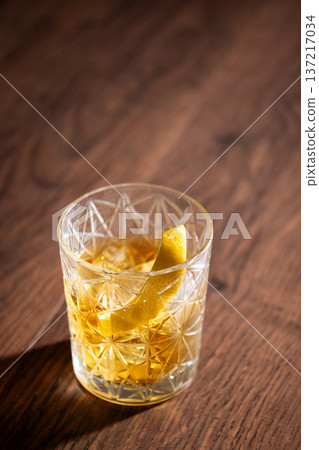 Rusty Nail Cocktail with Lemon Peel in Crystal Glas on Rustic Wooden Table. Copy space Rusty Nail Cocktail with Lemon Peel in Crystal Glas on Rustic Wooden Table. Copy space 137217034