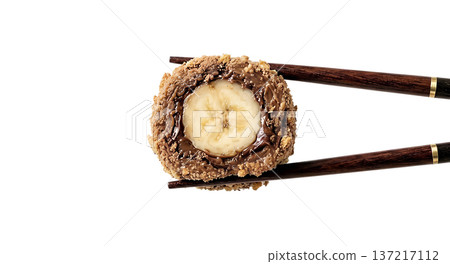 Creative dessert sushi roll made with banana, chocolate, elegantly held by chopsticks, isolated on transparent background 137217112